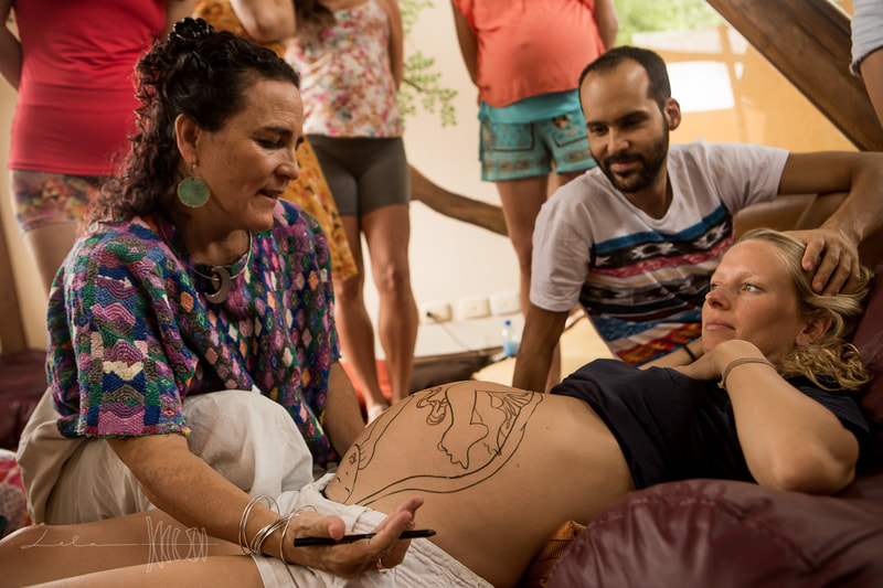 Natural Ultrasound is a technique created by Mexican Midwife Naoli Vinaver in 1992. Belly painted by Naoli Vinaver. Naoli painting belly and explaining position to parents. Photo by Lela Beltrão.