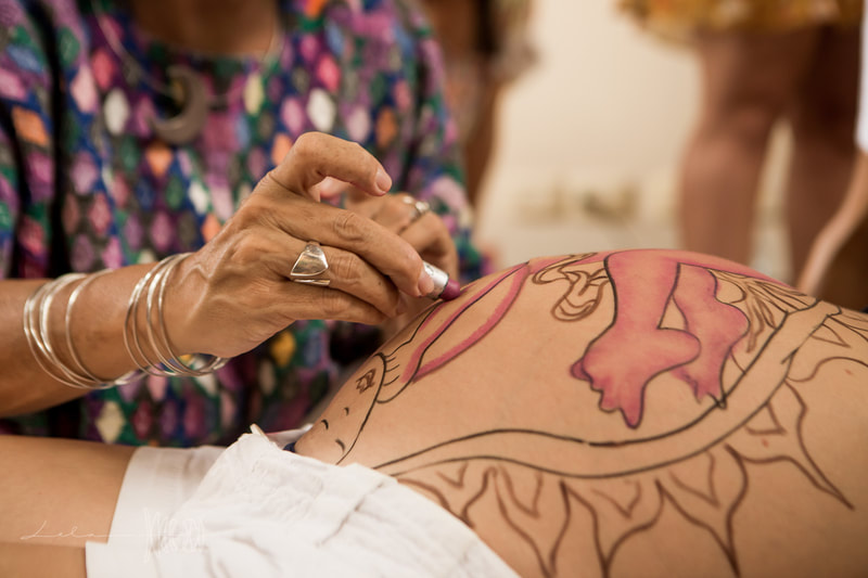 Natural Ultrasound is a technique created by Mexican Midwife Naoli Vinaver in 1992. Belly painting by Naoli Vinaver. Naoli painting belly and explaining procedure to parents. Photo by Lela Beltrão.