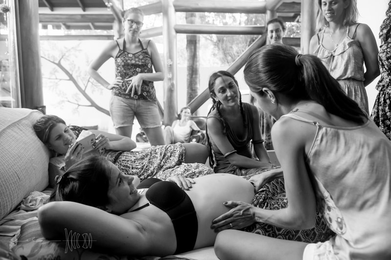 Students palpating pregnant belly to ascertain baby's position in Art of Birth workshop by Naoli Vinaver. Photo by Lela Beltrão. 