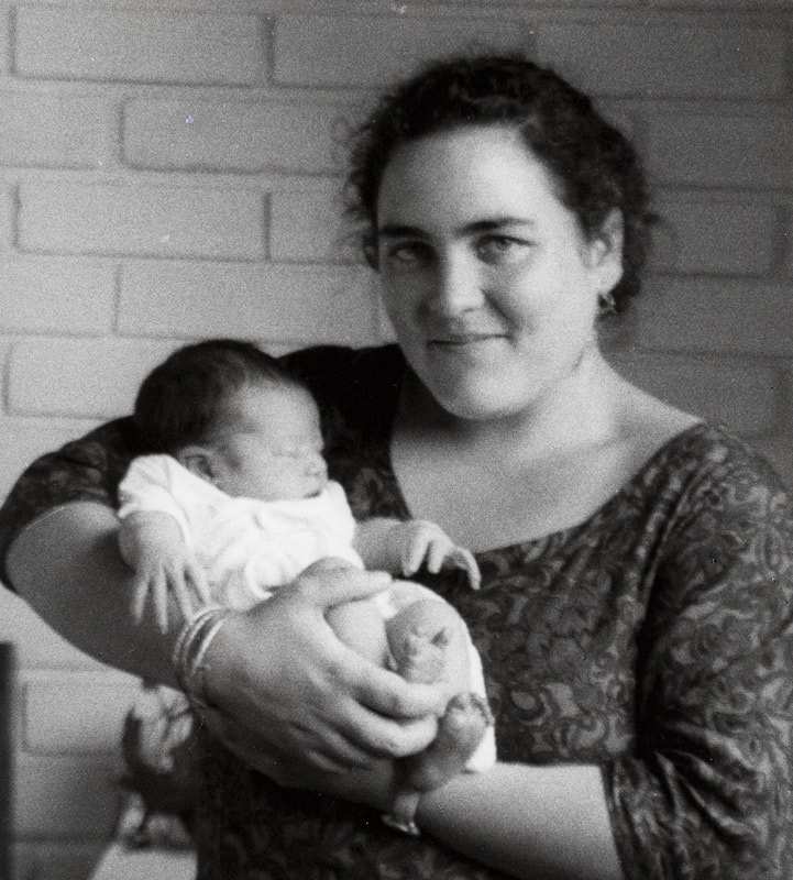 Naoli Vinaver holding a newborn baby who she was a midwife in childbirth